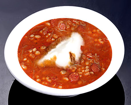 Фасолевый суп с колбасой и капустой в тарелке