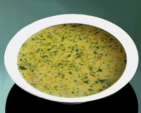 Сырный суп с зеленью в тарелке