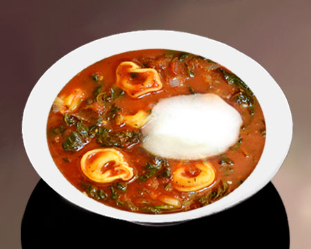 Томатный суп с пельменями и крапивой в тарелке