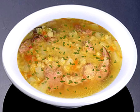 Гороховый суп с тушенкой и чесночной зажаркой в тарелке