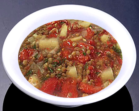 Суп из чечевицы с солеными помидорами в тарелке