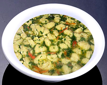 Овощной суп с галушками и зажаркой из паприки в тарелке