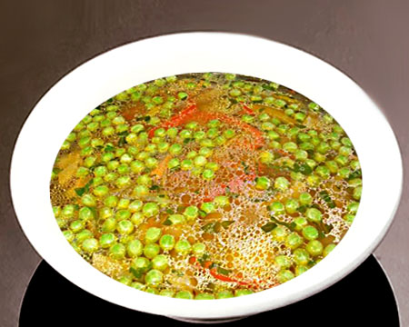 Суп из зеленого горошка с паприкой в тарелке
